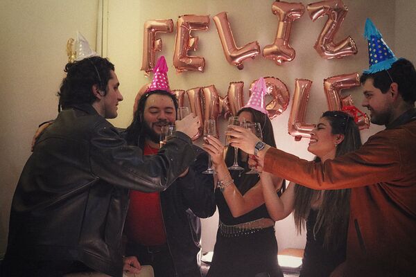Amis avec des chapeaux pointus qui trinquent pour un anniversaire