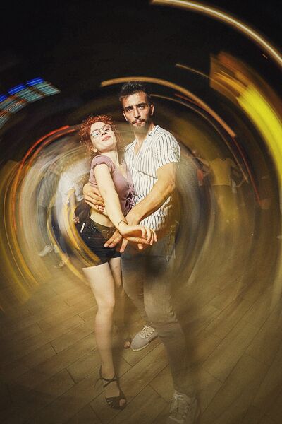 Un couple qui danse, pris en mouvement avec les lumières qui tournent